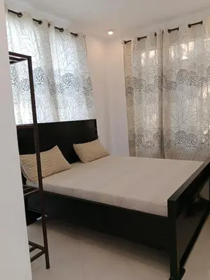 a bed in a room with curtains and a chair at Hidalgo Explorers Home in Moshi
