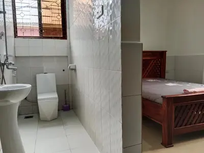 a bathroom with a bed and a sink and a toilet at Hidalgo Explorers Home in Moshi