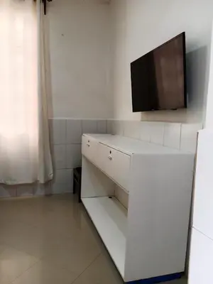 a white cabinet with a flat screen tv on a wall at Hidalgo Explorers Home in Moshi