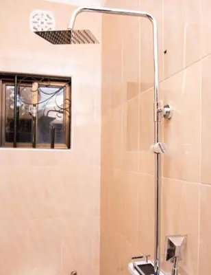a shower in a bathroom with a glass door at MSF one bedroom in Arusha