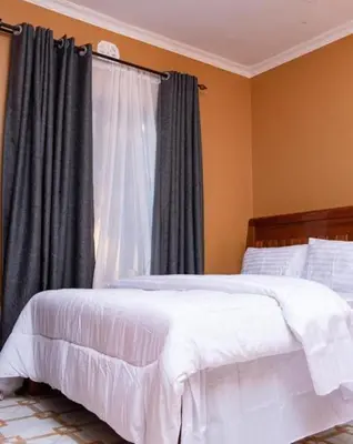 a bedroom with a white bed and a window at MSF one bedroom in Arusha