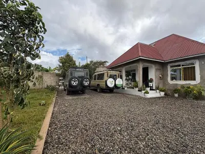 two old cars parked in front of a house at Sia in Tuvaila