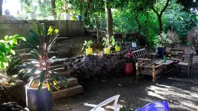 a garden with a table and benches and a stone wall at Eheruro Homestay in Arusha