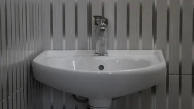 a white sink in a bathroom with a fosset at Eheruro Homestay in Arusha