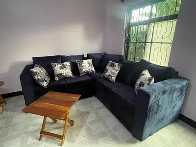 a blue couch in a living room with a table at Abba's Homestay in Arusha