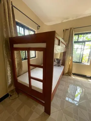 a bedroom with two bunk beds in a room at Abba's Homestay in Arusha