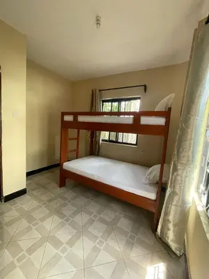 a bedroom with two bunk beds in a room at Abba's Homestay in Arusha