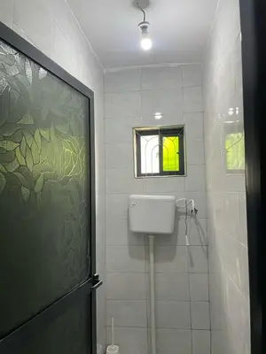 a bathroom with a shower with a toilet and a window at Abba's Homestay in Arusha