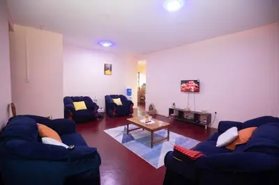 a living room with two blue couches and a table at Bantulaki House in Arusha