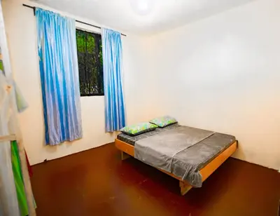 a bedroom with a bed in a room with blue curtains at Bantulaki House in Arusha