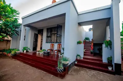 a white house with a staircase leading to it at Bantulaki House in Arusha