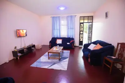 a living room with two blue couches and a table at Bantulaki House in Arusha