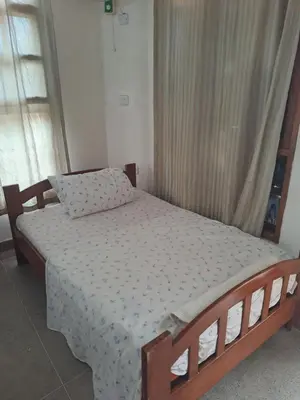 a bedroom with a bed with a wooden frame at Hans kili home in Moshi