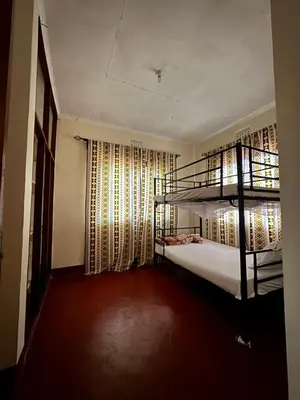 a room with two bunk beds and a window at The Hut Hostel in Arusha