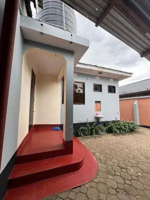 a house with a red floor and a building at The Hut Hostel in Arusha