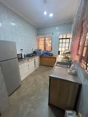 a kitchen with a sink and a refrigerator at Kiliastra Homes in Moshi