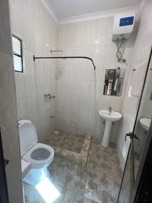 a bathroom with a toilet and a sink at Kiliastra Homes in Moshi