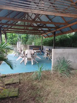 a patio with tables and chairs under a wooden pergola at Kiliastra Homes in Moshi