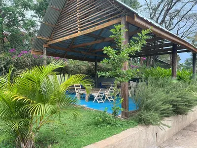 a pavilion with chairs and a pool in a garden at Kiliastra Homes in Moshi
