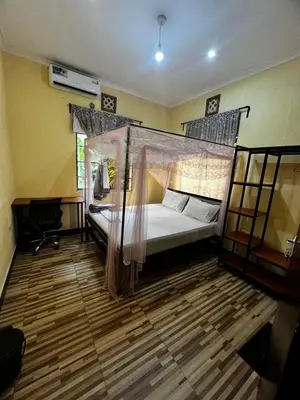a bedroom with a bed with a mosquito net at Kiliastra Homes in Moshi