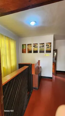 a room with a staircase with paintings on the wall at Mardai Homestay in Arusha