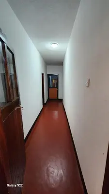an empty hallway with a red floor and a door at Mardai Homestay in Arusha