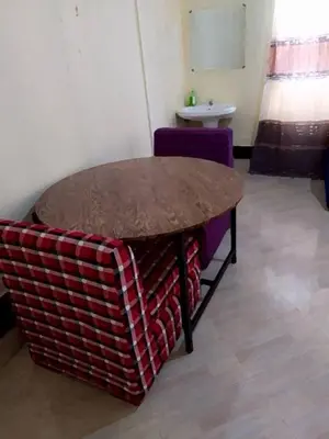 a table and a chair in a room at Arusha Sunbird Lodge in Arusha