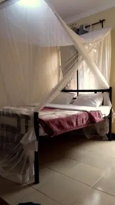 a bunk bed with a canopy in a room at Arusha Sunbird Lodge in Arusha