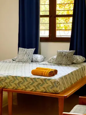 a bed in a room with a blue curtain at Kivuli Lodge in Moshi