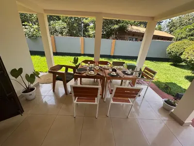 a dining room table and chairs on a patio at Kivuli Lodge in Moshi