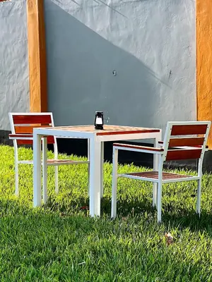 two chairs sitting next to a table and a table and chairs at Kivuli Lodge in Moshi
