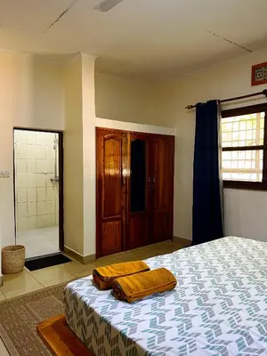 a bedroom with a bed with two towels on it at Kivuli Lodge in Moshi