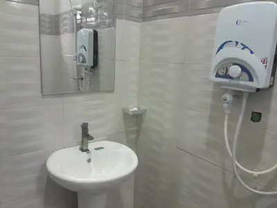 a white bathroom with a sink and a shower at STAN LODGE Babati in Babati