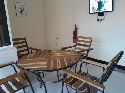 a wooden table and chairs in a room at STAN LODGE Babati in Babati