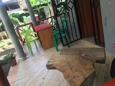 a room with a table and chairs on a porch at Humphrey home stay in Arusha