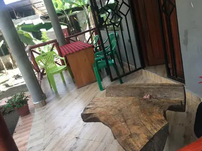 a balcony with a wooden floor and a table and chairs at Humphrey home stay in Arusha