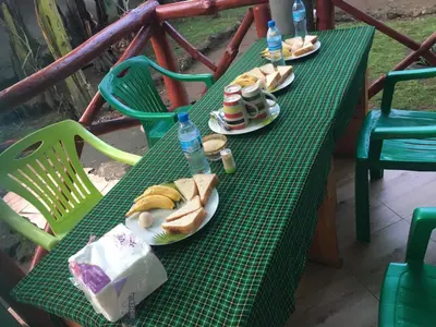 a green table with plates of sandwiches and water bottles at Humphrey home stay in Arusha