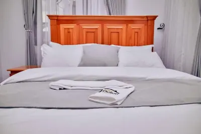 a pair of white towels sitting on top of a bed at Lake duluti serenity villas in Arusha