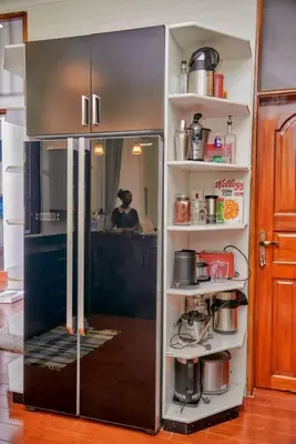 a refrigerator in a kitchen with a person taking a picture at Lake duluti serenity villas in Arusha