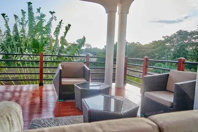 a porch with chairs and a couch and a table at Lake duluti serenity villas in Arusha
