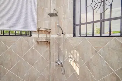 a shower stall in a bathroom with a window at Lake duluti serenity villas in Arusha
