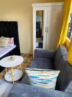 a living room with a couch and a table at Comfort studio apartment in Arusha