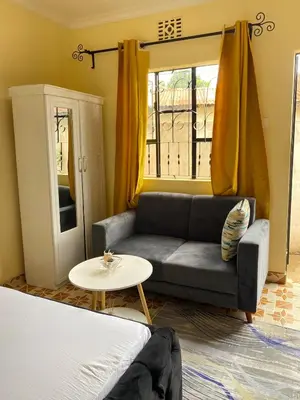 a living room with a couch and a table at Comfort studio apartment in Arusha