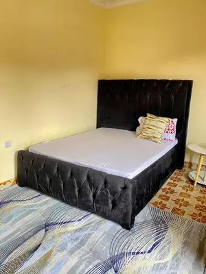 a bed with a black headboard in a room at Comfort studio apartment in Arusha