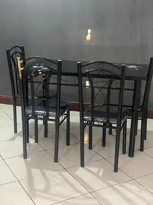 a black table with two black chairs around it at Mila home in Arusha