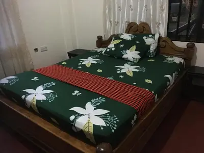 a bed with green and white flowers on it at Humphrey home stay in Arusha