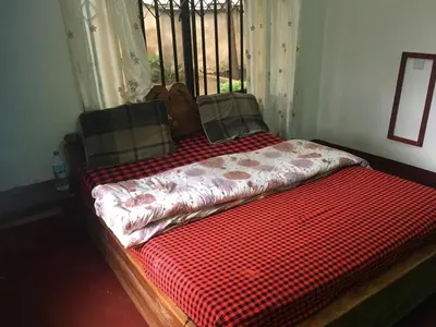 a bed with a red comforter in a room at Humphrey home stay in Arusha