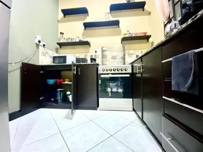 a kitchen with black cabinets and an oven at Our Home your Home in Arusha in Nkoanrua