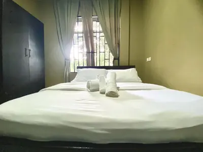 a bed with two towels on it with a window at Our Home your Home in Arusha in Nkoanrua