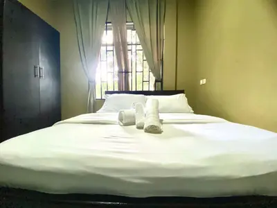 a large white bed with towels on it with a window at Our Home your Home in Arusha in Nkoanrua